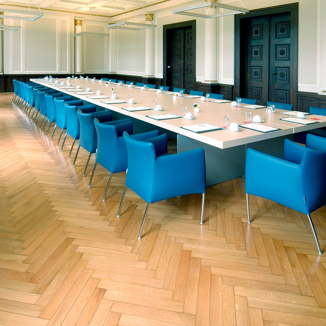 Konferenzraum mit Holzparkett und blauen Stühlen