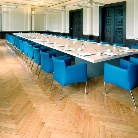 Konferenzraum mit Holzparkett und blauen Stühlen