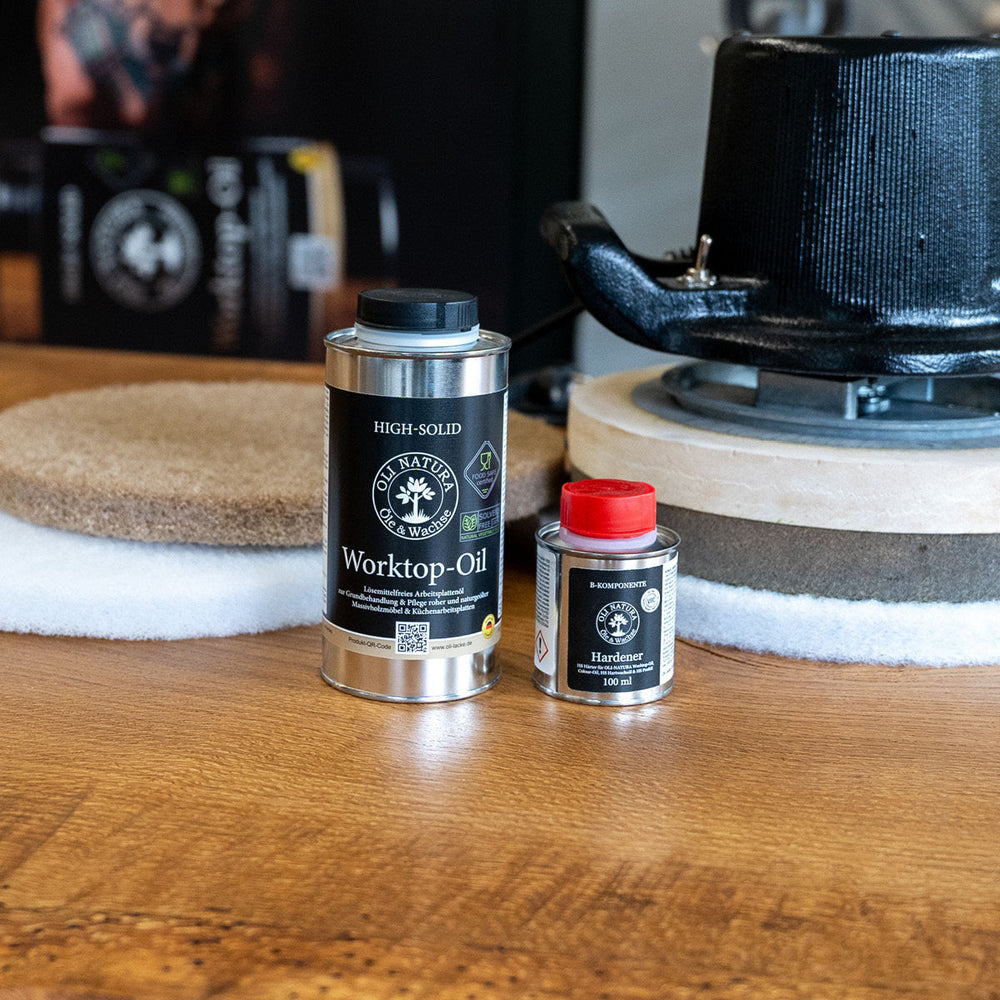 OLI-NATURA Worktop-Oil und Hardener neben einer Poliermaschine auf einer Holzplatte
